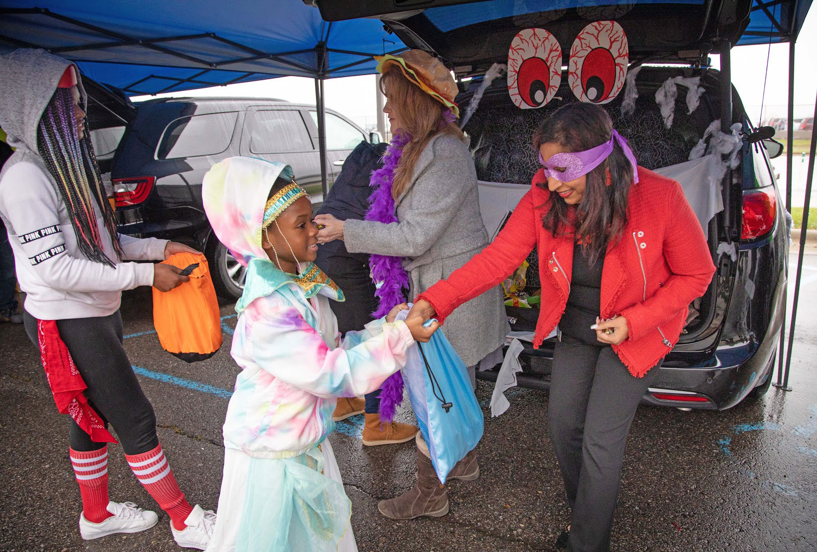 Barbara Pilarksi (center), Head of Business Development, FCA–North America and Mamatha Chamarthi (right), Chief Information Officer, FCA–North America and Asia Pacific, help fill trick-or-treat bags with candy.